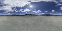 a panoramic image of clouds and mountains on the horizon with the sky above them