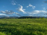 a lone country road is in the countryside area with mountains on both sides and barbed fence between the two sides