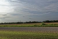 two large grain bins sit in the center of a field, surrounded by silos