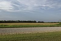 two large grain bins sit in the center of a field, surrounded by silos