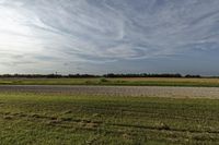 two large grain bins sit in the center of a field, surrounded by silos
