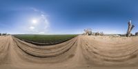 the panoramic photo shows a dirt field with tractor tracks, and other machinery