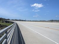 the bridge is surrounded by a long strip of dirt and grass that stretches into the distance