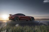 a mercedes s gts parked on the road at sunset with grass in the foreground