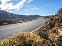 this is a picture of the desert road in the middle of nowhere with rocks and grass around