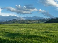 a lone country road is in the countryside area with mountains on both sides and barbed fence between the two sides