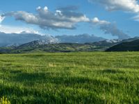 a lone country road is in the countryside area with mountains on both sides and barbed fence between the two sides