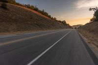 view of a highway with a hillside in the background as seen from a vehicle on a road trip