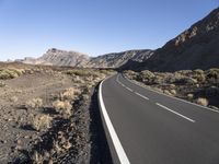 empty paved road going through the rocky mountainside during winter months, outdoors near desert, high