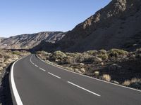 empty paved road going through the rocky mountainside during winter months, outdoors near desert, high