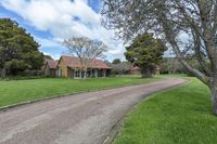 the large house is surrounded by trees and grass on the other side of the road