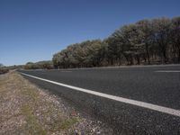 a motorcycle is parked next to a highway that stretches along the side of the road