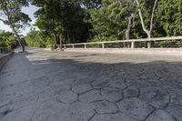 a concrete bridge over a city street with trees in the background behind it and a man riding his bike