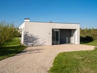 a house that is built using small concrete structures and glass doors with two large windows