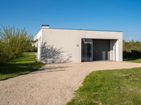 a house that is built using small concrete structures and glass doors with two large windows