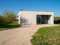 a house that is built using small concrete structures and glass doors with two large windows