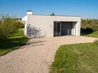 a house that is built using small concrete structures and glass doors with two large windows