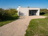 a house that is built using small concrete structures and glass doors with two large windows