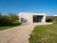 a house that is built using small concrete structures and glass doors with two large windows