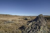 an interesting rock formation in the middle of the wilderness, with mountains in the background