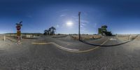 360 - view of road with fence, sign and pole for a stoplight in the middle of nowhere