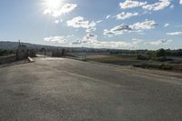 view down a empty country side road looking over a gate and towards the hills in distance