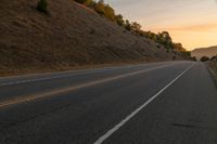 a photo of a country road with sun setting behind it from the back seat of a car