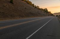 a photo of a country road with sun setting behind it from the back seat of a car