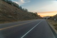 a photo of a country road with sun setting behind it from the back seat of a car