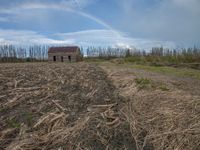 a little house in the middle of a field under a rainbow in the sky at a farm