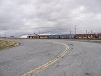 an empty parking lot with tracks and freight train cars on it while there is no one on the tracks