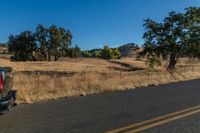 a motorcycle traveling down the road near a rural area with trees on either side of it