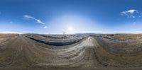 a 360 - pane image showing dirt terrain in the desert under blue sky and clouds