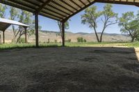 an open covered area with a view of the mountain range in the distance outside of the building