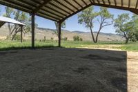 an open covered area with a view of the mountain range in the distance outside of the building