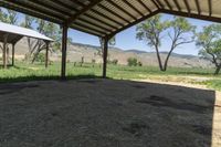 an open covered area with a view of the mountain range in the distance outside of the building