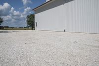 the garage has white wall and gravel around it for an additional purpose, or in any style