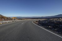 a highway sign in a barren landscape with mountains behind it as seen from the road