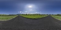 a photo taken while on a 360 - turn street in the countryside with a sky and sun