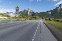 a street going down a highway with a mountain in the background and a cell tower on top