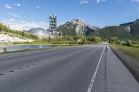 a street going down a highway with a mountain in the background and a cell tower on top