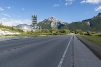 a street going down a highway with a mountain in the background and a cell tower on top