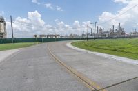 a large cement plant is pictured on the side of a road near an empty field