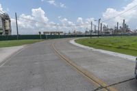 a large cement plant is pictured on the side of a road near an empty field