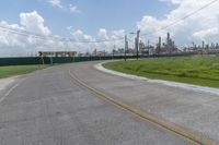 a large cement plant is pictured on the side of a road near an empty field