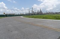 a large cement plant is pictured on the side of a road near an empty field