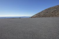 an empty parking lot and a mountain in the background with one white object in it