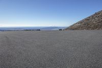 an empty parking lot and a mountain in the background with one white object in it