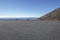 an empty parking lot and a mountain in the background with one white object in it