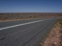 a deserted street with two white lines leading into the distance and another line along the road